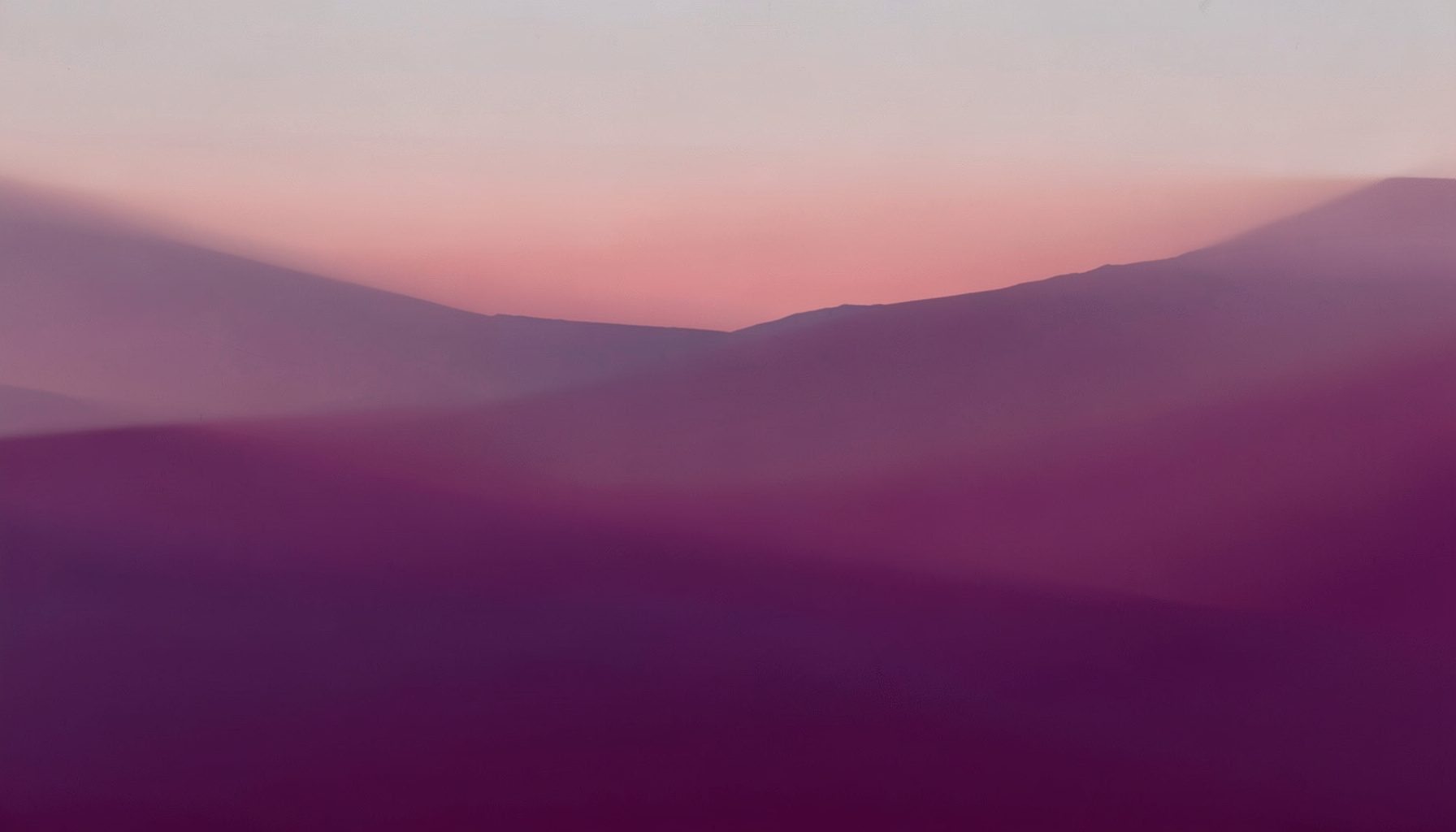 Soft abstract gradient blending muted plum and dusty rose tones evoking a calm Mediterranean dusk